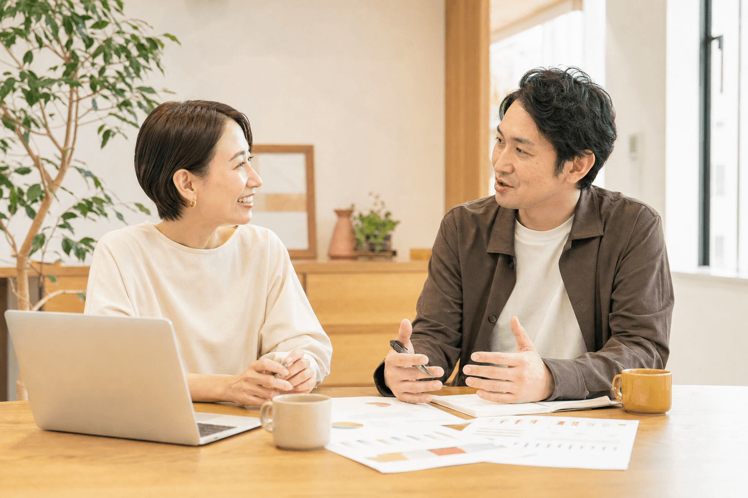 明るいオフィスで経営者とコンサルタントが対話する様子